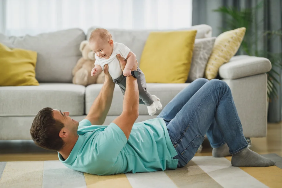 Father holding his baby, representing everyday use of a rotating car seat